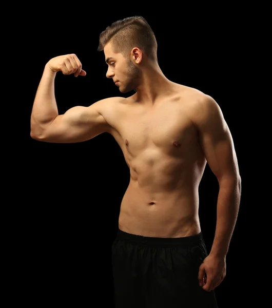 Muscle jeune homme sur fond sombre — Photo