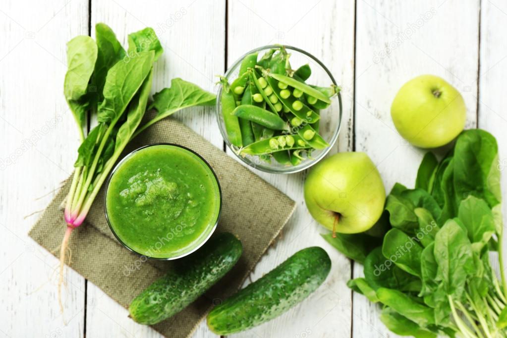 Healthy green smoothie on wooden table, top view