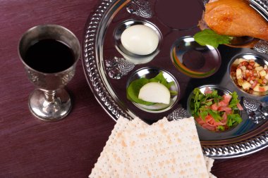 Matzo for Passover with Seder meal with wine on plate on table close up clipart