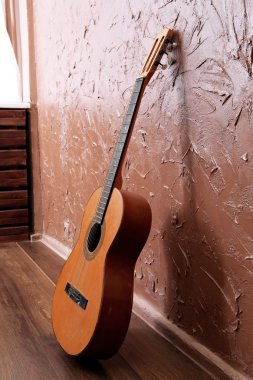 kahverengi duvar arka plan üzerinde klasik akustik gitar