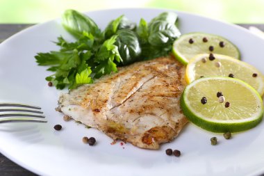 Balık fileto Yeşiller ve kireç plaka üzerinde tabak kapat