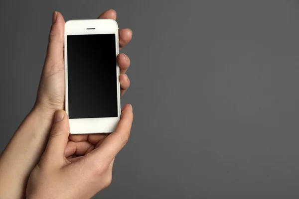 灰色の背景に両手モバイル スマート フォン — ストック写真