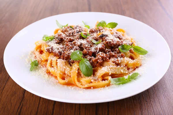 Massa Bolonhesa com parmesão e manjericão na mesa de perto — Fotografia de Stock