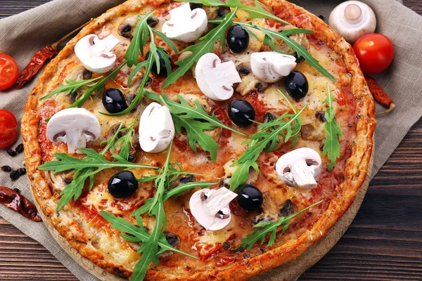 Välsmakande pizza med grönsaker och rucola på bordet på nära håll — Stockfoto