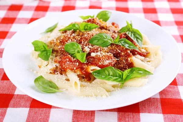 Pâtes avec sauce tomate et basilic sur la table close up — Photo