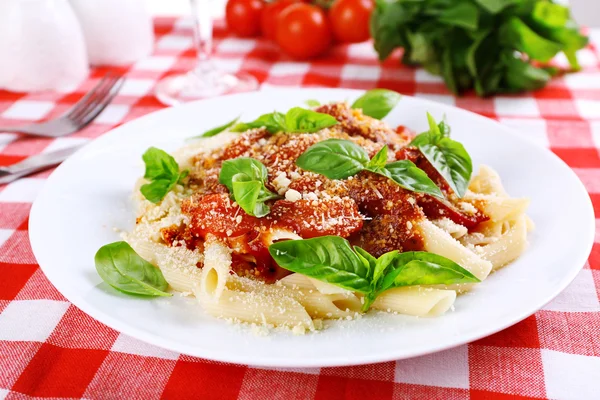 Pasta with tomato sauce and basil on table close up — Stock Photo, Image