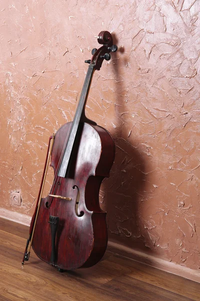 Klassisches Cello und Bogen auf braunem Hintergrund — Stockfoto