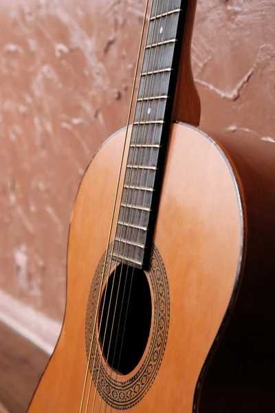 Guitarra acústica clásica sobre fondo de pared marrón —  Fotos de Stock