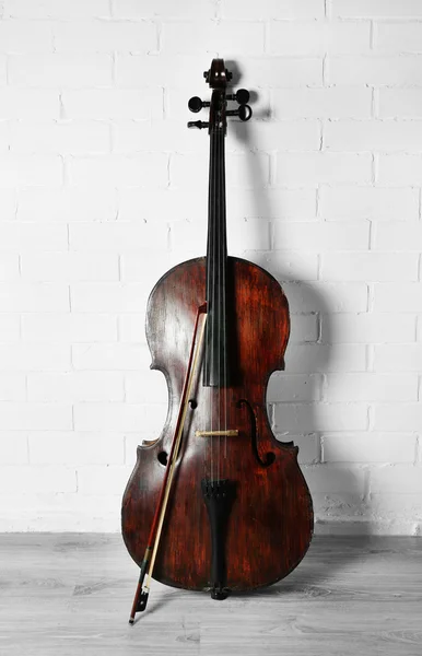 Cello auf weißem Backstein-Hintergrund — Stockfoto