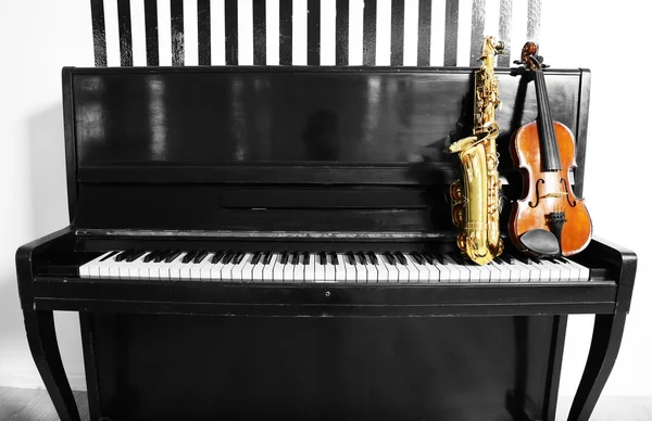 Geige und Saxophon auf Klavierhintergrund — Stockfoto