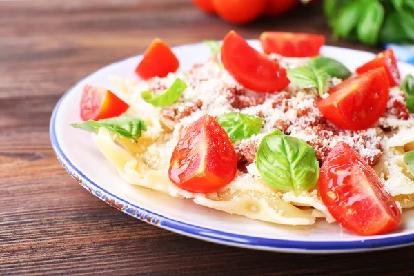 Pâtes bolognaise aux tomates cerises en assiette blanche sur table en bois, gros plan — Photo