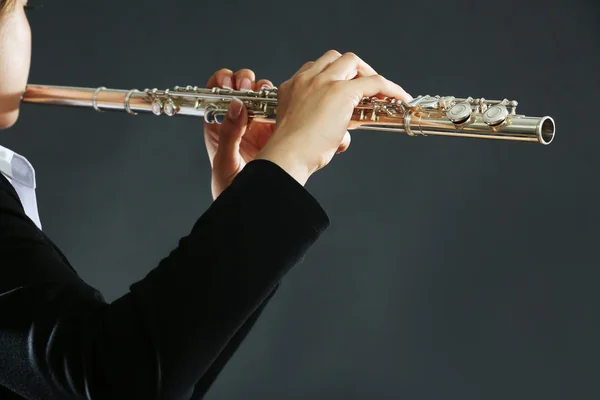 Musician playing flute on dark background — Stock Photo, Image