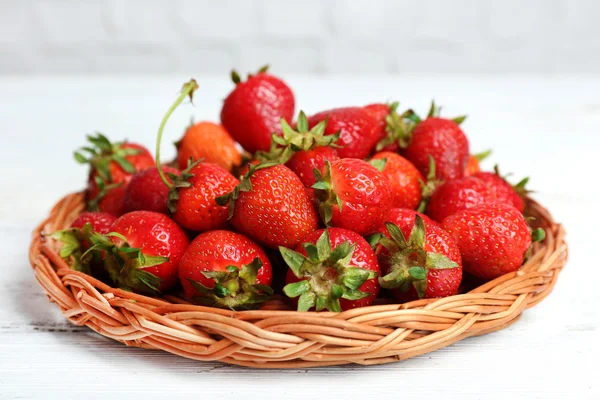 Reife Erdbeeren in Weidenschale auf Holztisch, Nahaufnahme — Stockfoto