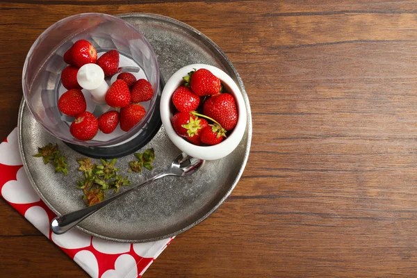 Zralé jahody v mixéru na kovový zásobník na dřevěný stůl, pohled shora — Stock fotografie
