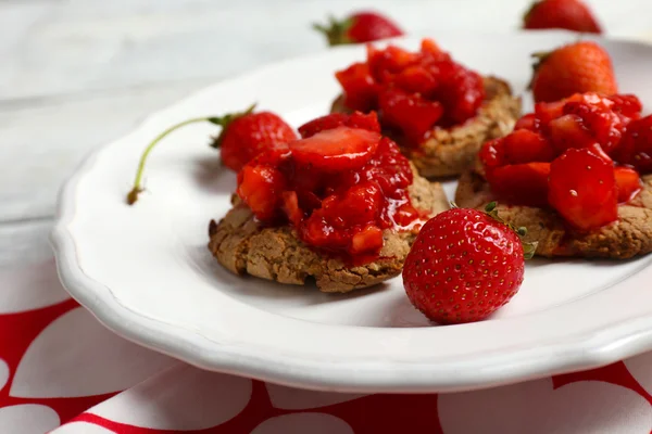 Biscuits à la fraise fraîche dans une assiette sur une table en bois, gros plan — Photo