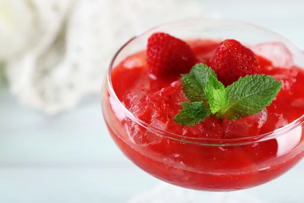 Dolce alla fragola congelato in vetro, su tavolo di legno, su sfondo chiaro — Foto Stock