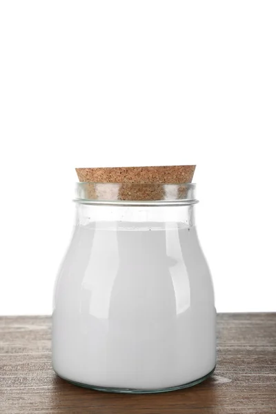 Glass jar of milk on wooden table, on white background — Stock Photo, Image