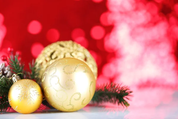 Schöne Weihnachtskugeln auf rotem verschwommenem Hintergrund — Stockfoto