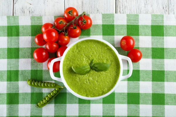 Tasty peas soup and cherry tomatoes on table close up — Stock Photo, Image