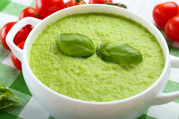 Tasty peas soup and cherry tomatoes on table close up — Stock Photo, Image