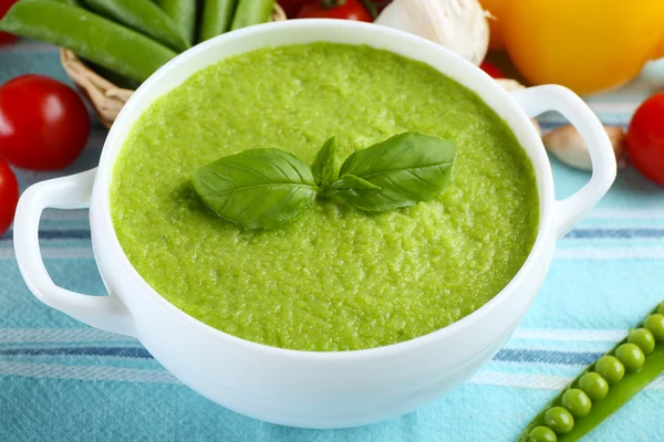 Tasty peas soup and vegetables on table close up — Stock Photo, Image