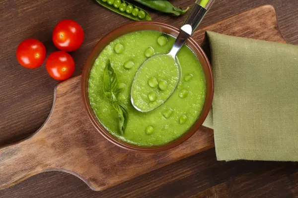 Tasty peas soup and cherry tomatoes on table close up — Stock Photo, Image