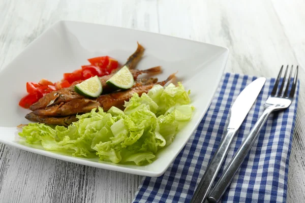 Pequeno peixe frito com legumes na mesa de perto — Fotografia de Stock