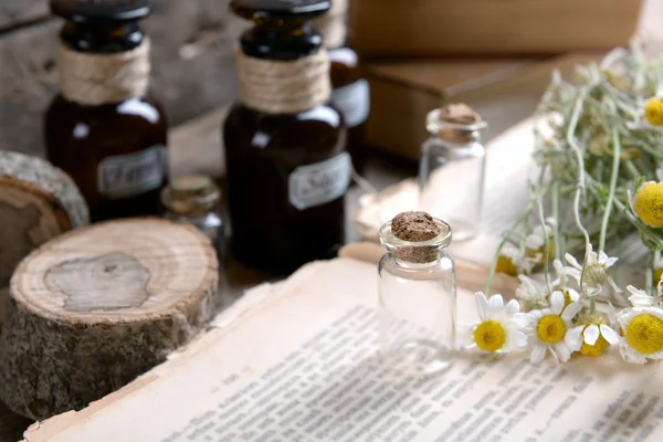 Libro viejo con flores secas y botellas en la mesa de cerca —  Fotos de Stock