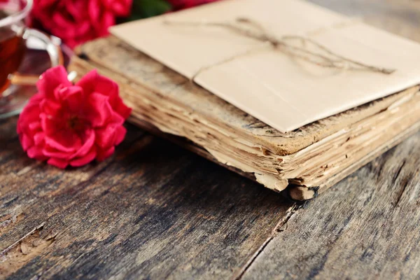Old book with beautiful flowers on wooden table close up — Stock Photo, Image