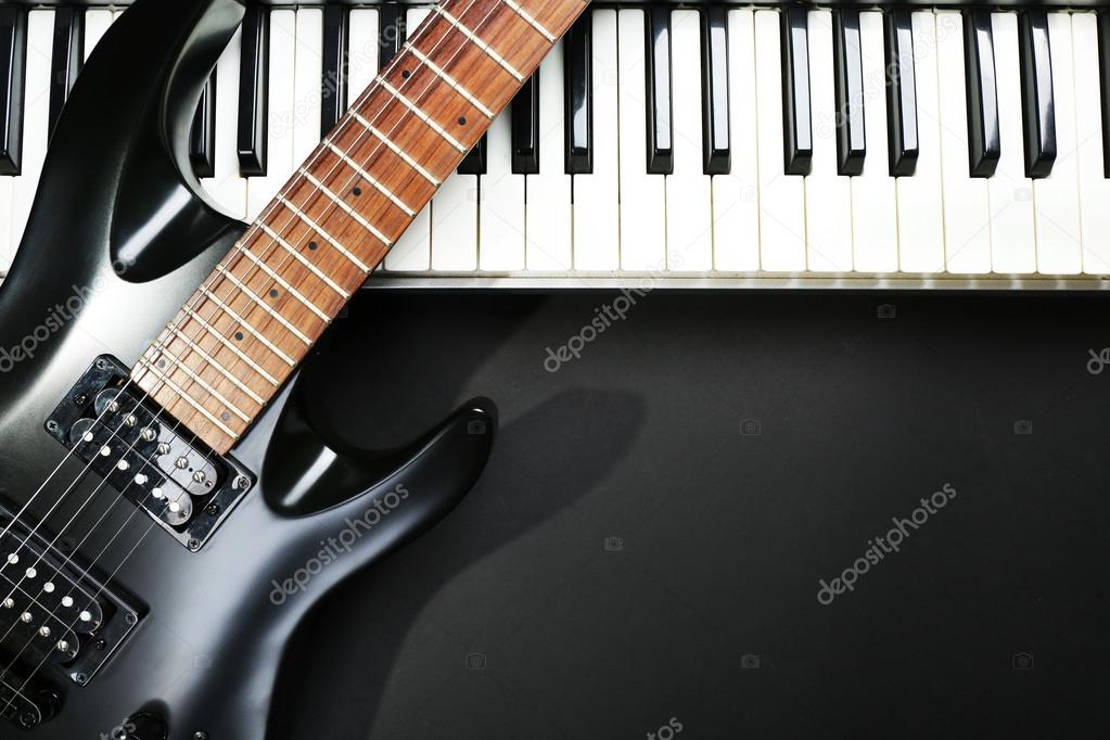 Synthesizer and electric guitar on dark background