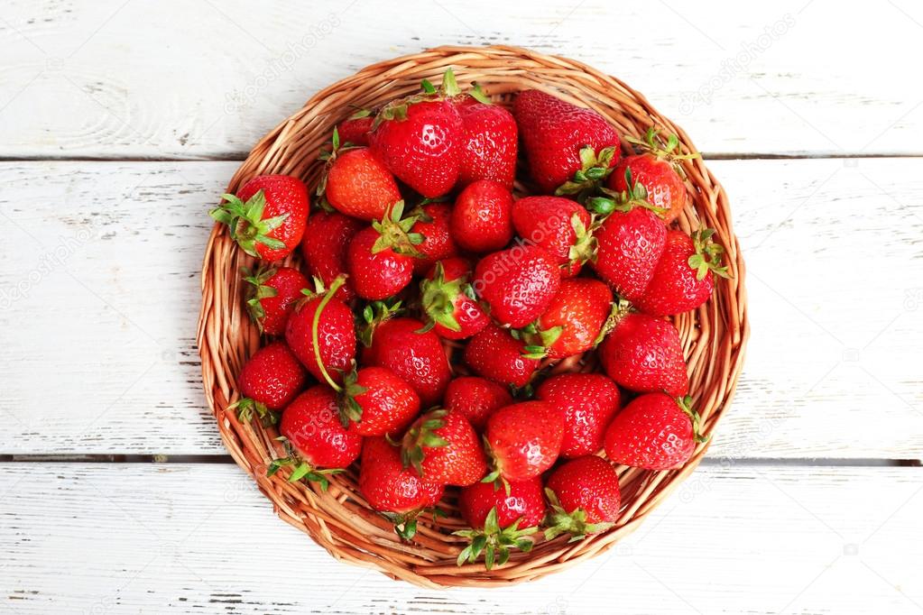 Ripe strawberries in wicker tray, top view