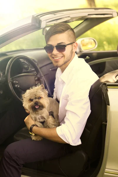 Joven con lindo perro en cabriolet, al aire libre — Foto de Stock