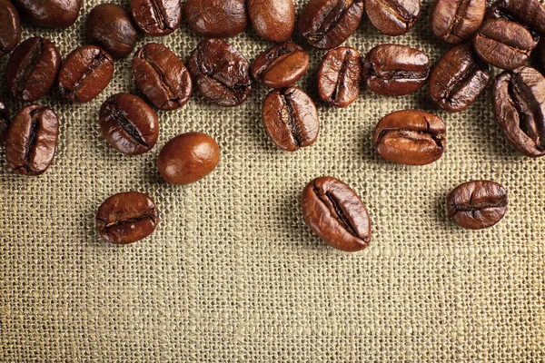 Marco de granos de café sobre fondo de saco de color — Foto de Stock