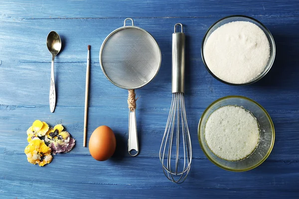 Herstellung von kandierten violetten Blüten mit Eiweiß und Zucker, auf farbigem Holzhintergrund — Stockfoto