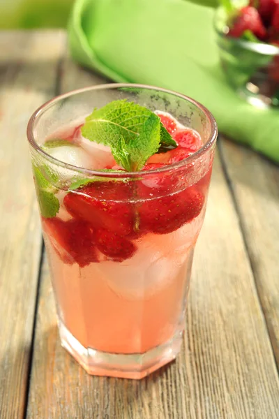 El vaso del jugo de fresa con las bayas a la mesa se acercan —  Fotos de Stock