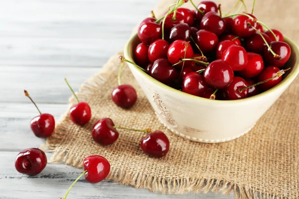 Fresh cherries in bowl with sackcloth — Stock Photo, Image