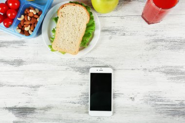 Gıda ve ahşap arka plan üstünde hareket eden telefon