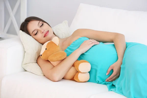 Pregnant woman lying on sofa in room — Stock Photo, Image