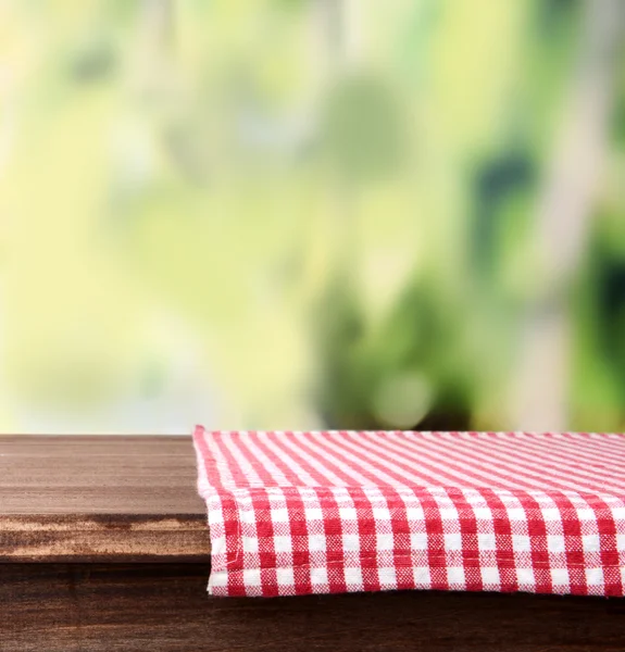 Empty wooden table with napkin on bright background — Stock Photo, Image