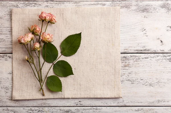 Schöne trockene Blumen auf Serviette auf Holzgrund — Stockfoto
