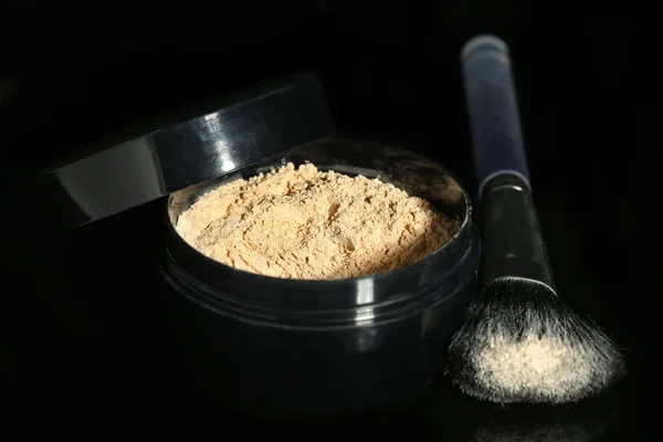 Jar met losse cosmetische poeder en make-up borstel, geïsoleerd op zwart — Stockfoto