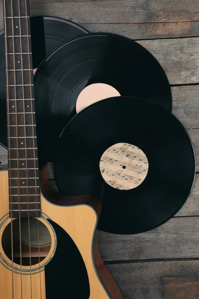 Guitarra e discos de vinil em mesa de madeira de perto — Fotografia de Stock