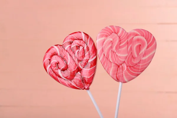 Lollipops brillantes en forma de corazón sobre fondo de madera —  Fotos de Stock