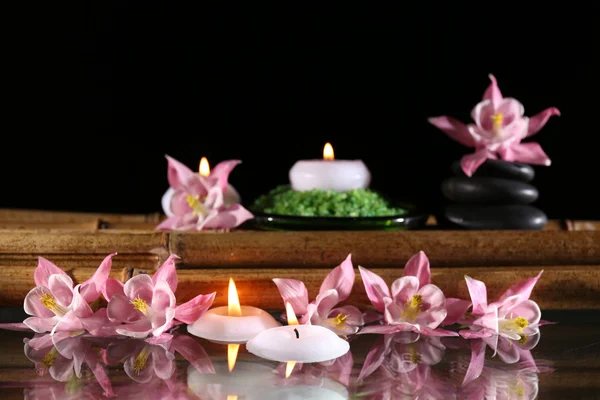 Prachtige spa samenstelling met bloemen en kaarsen op zwarte achtergrond — Stockfoto