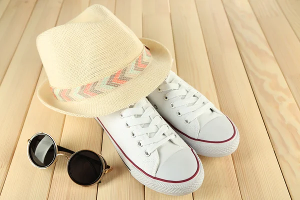 Cappello e occhiali da sole da donna su sfondo di legno — Foto Stock