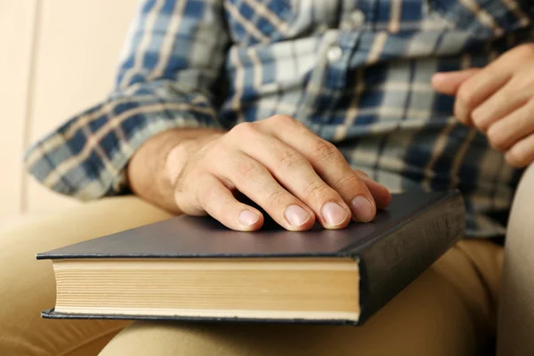 Young man with book on sofa close up — Stock Photo, Image