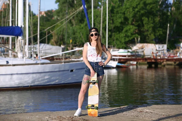 Belle fille tatouée avec planche à roulettes, en plein air — Photo