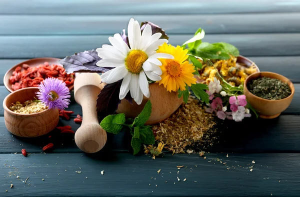 Kruiden, bessen en bloemen op een houten tafel achtergrond kleur — Stockfoto