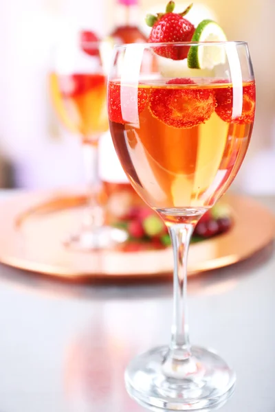 Glasses of wine with strawberries and lime on blurred background — Stockfoto