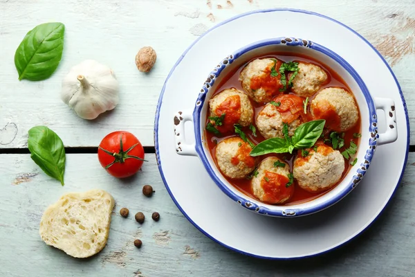 Bolas de carne con salsa de tomate e ingredientes sobre fondo de madera — Foto de Stock